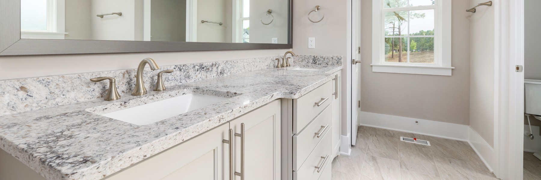 Remodeled bathroom with granite double vanity and tile floor
